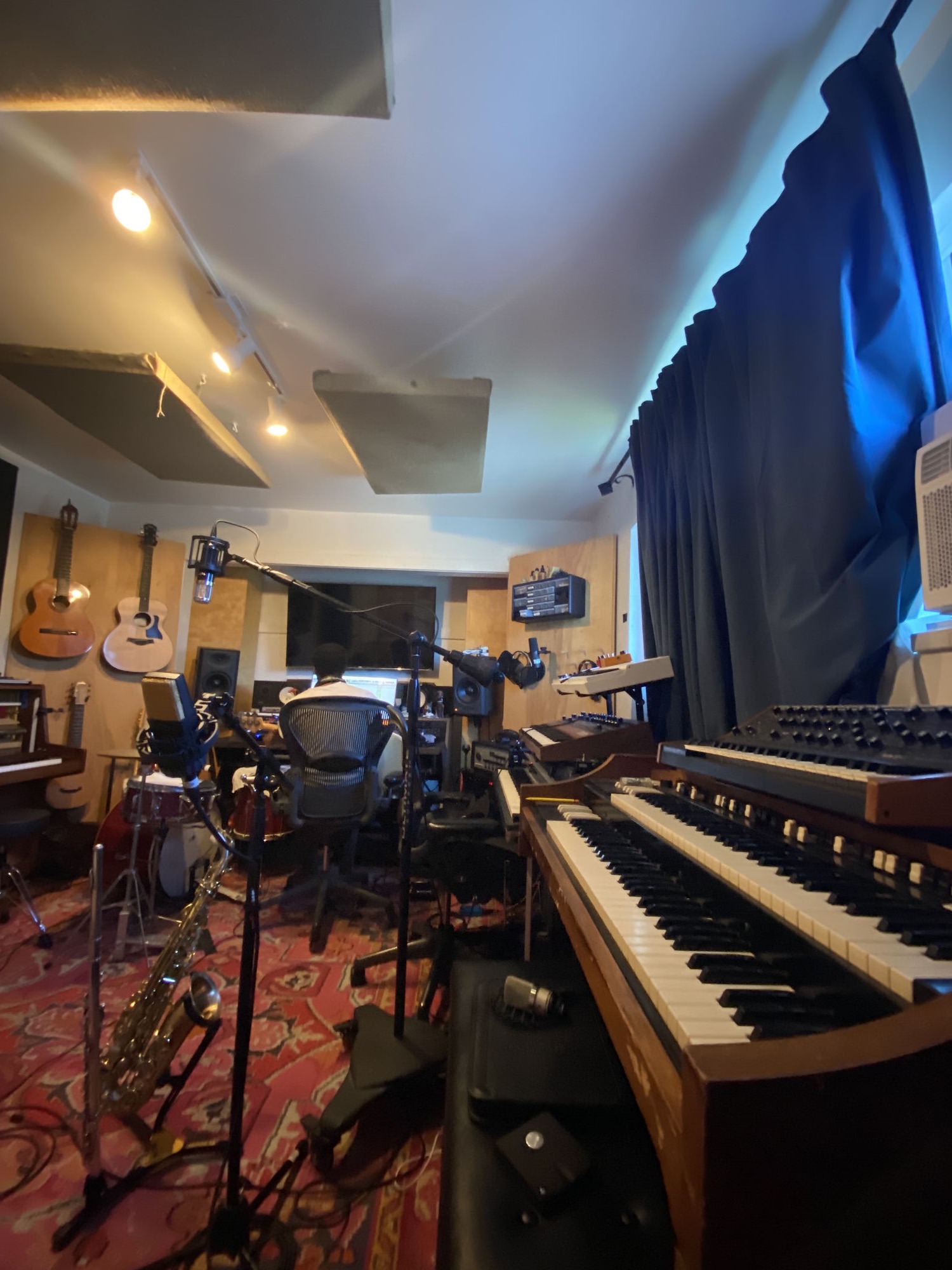 Full studio room with guitars, organ, and microphones
